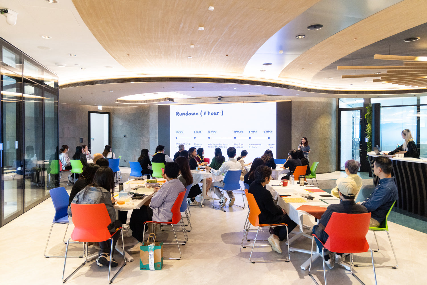 Corporate workers attentively listen to Superwrap's educational talk on sustainability practices, ESG, and upcycling in a modern office setting