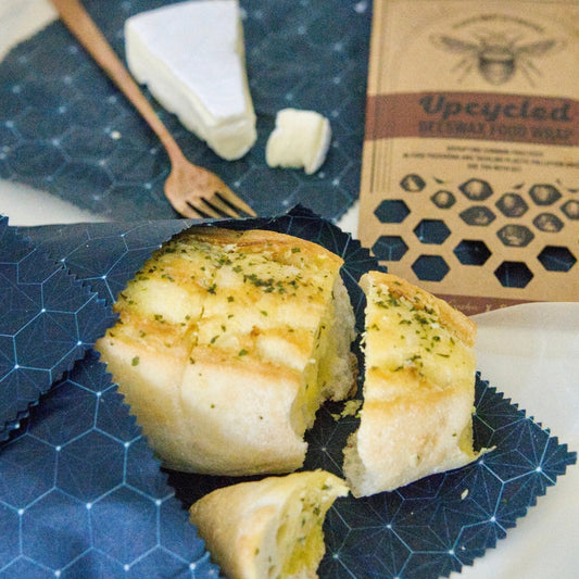 A loaf of bread wrapped in Superwrap’s upcycled beeswax wrap in the ‘Navy Hive’ design
